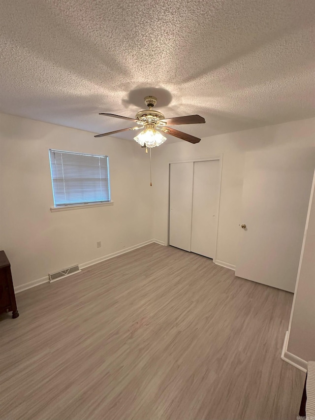 900 Davidson Cir, Edgemont, AR 72044 - unfurnished bedroom featuring a textured ceiling, light wood finished floors, ceiling fan, and a closet