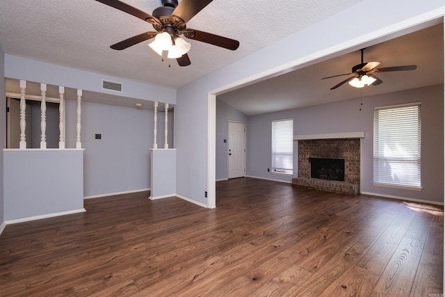 1905 Broken Bow, North Little Rock, AR 72116 - unfurnished living room with a ceiling fan, wood finished floors, a brick fireplace, lofted ceiling, and a textured ceiling