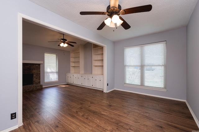 1905 Broken Bow, North Little Rock, AR 72116 - unfurnished living room featuring a ceiling fan, a textured ceiling, dark wood finished floors, a brick fireplace, and built in features