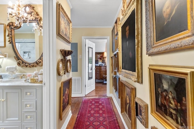 7111 W Markham St, Little Rock, AR 72205 - hallway featuring crown molding, a chandelier, and wood finished floors