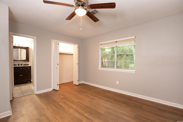 6905 White Oak Cv, White Hall, AR 71602 - unfurnished bedroom with wood finished floors, connected bathroom, a ceiling fan, a textured ceiling, and a closet