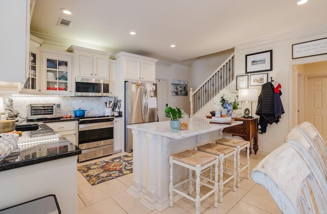 410A Halteria, Hot Springs, AR 71913 - kitchen with stainless steel appliances, light tile patterned flooring, backsplash, a breakfast bar area, and a center island