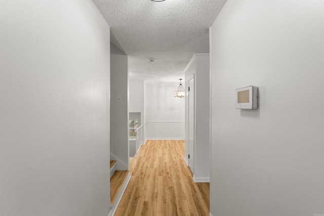 4901 Westwood Ave, Little Rock, AR 72204 - hall featuring a textured ceiling, light wood-style flooring, and a chandelier