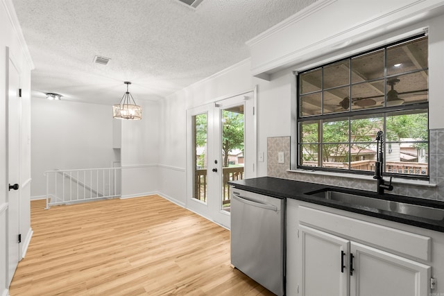 4901 Westwood Ave, Little Rock, AR 72204 - kitchen featuring stainless steel dishwasher, a textured ceiling, light wood-style flooring, dark countertops, and white cabinetry