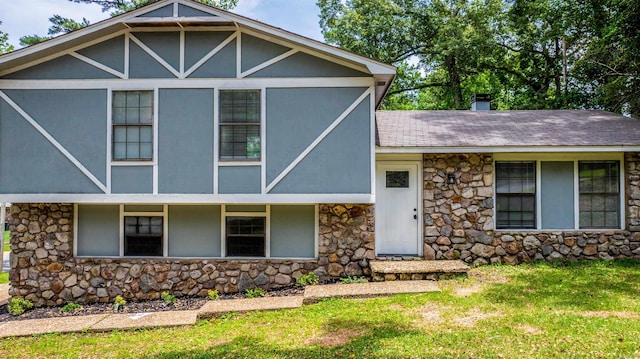 4901 Westwood Ave, Little Rock, AR 72204 - tudor-style house featuring stone siding, a front yard, and a shingled roof