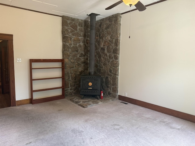 408 Case St, Heber Springs, AR 72543 - unfurnished living room featuring a wood stove, carpet, and ceiling fan