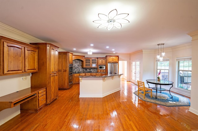22 Jacob Pl, Little Rock, AR 72211 - kitchen with stainless steel refrigerator, brown cabinetry, glass insert cabinets, a kitchen bar, and light wood-style floors