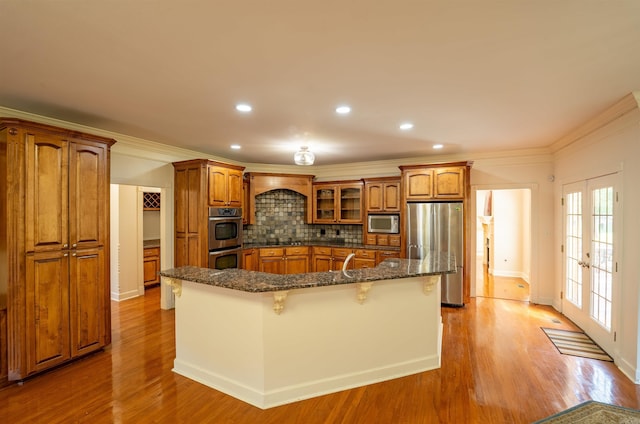 22 Jacob Pl, Little Rock, AR 72211 - kitchen with appliances with stainless steel finishes, brown cabinets, a kitchen bar, recessed lighting, and ornamental molding