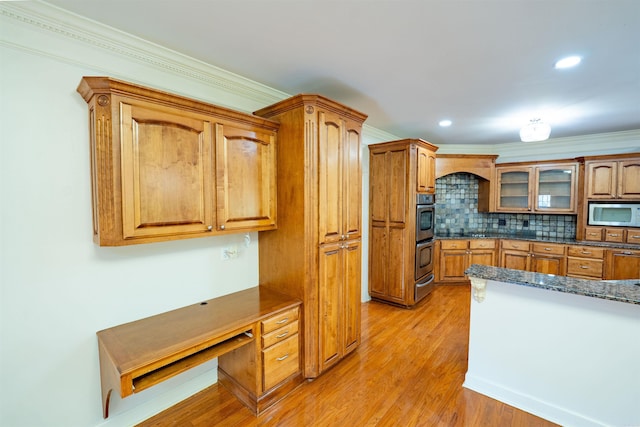22 Jacob Pl, Little Rock, AR 72211 - kitchen featuring appliances with stainless steel finishes, a warming drawer, light wood-style flooring, brown cabinets, and decorative backsplash