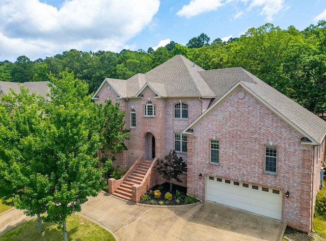 22 Jacob Pl, Little Rock, AR 72211 - view of front facade featuring an attached garage, brick siding, driveway, and a shingled roof