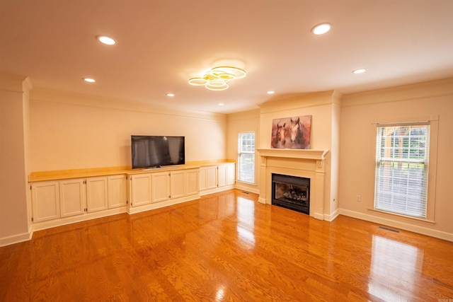 22 Jacob Pl, Little Rock, AR 72211 - unfurnished living room featuring plenty of natural light, a fireplace, light wood-style floors, crown molding, and recessed lighting