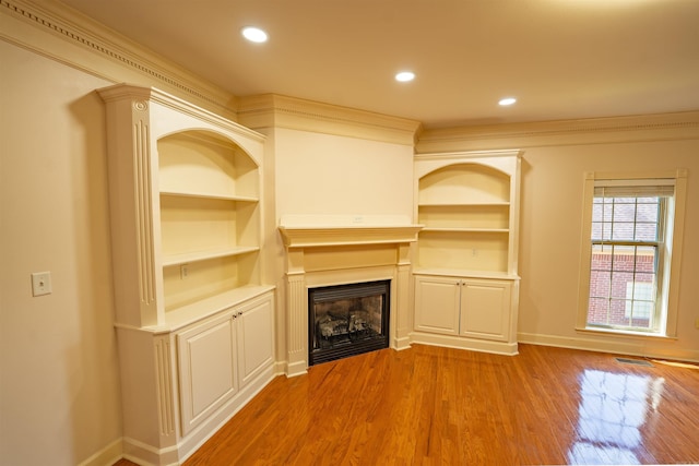 22 Jacob Pl, Little Rock, AR 72211 - unfurnished living room featuring a fireplace, wood finished floors, built in features, recessed lighting, and crown molding