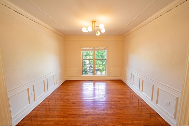 22 Jacob Pl, Little Rock, AR 72211 - empty room featuring a chandelier, a decorative wall, ornamental molding, wood finished floors, and a wainscoted wall