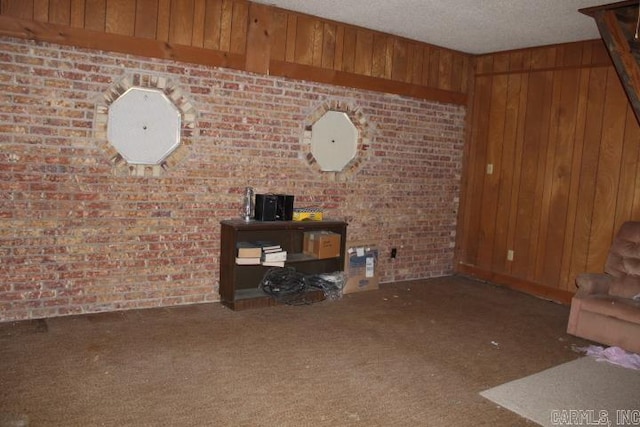 22213 N Springlake Rd, Hensley, AR 72065 - unfurnished living room featuring carpet floors, wood walls, a textured ceiling, and brick wall