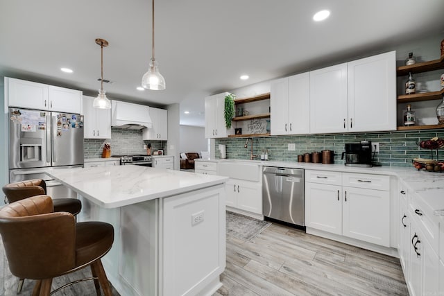 2709 Ottawa Dr, North Little Rock, AR 72116 - kitchen featuring open shelves, stainless steel appliances, tasteful backsplash, custom range hood, and a kitchen island