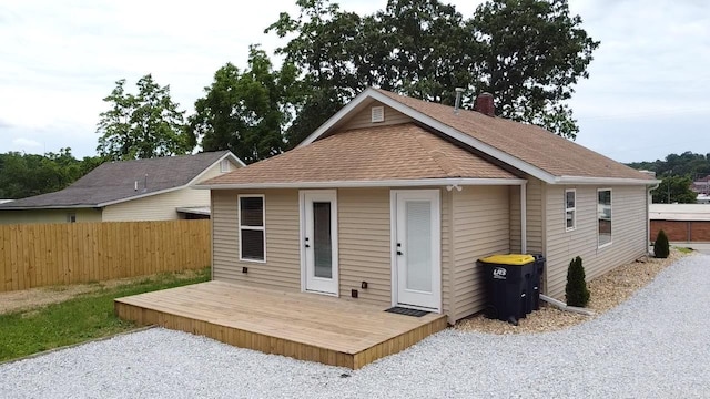 219 N Chestnut St, Harrison, AR 72601 - rear view of house featuring a wooden deck, roof with shingles, and a chimney