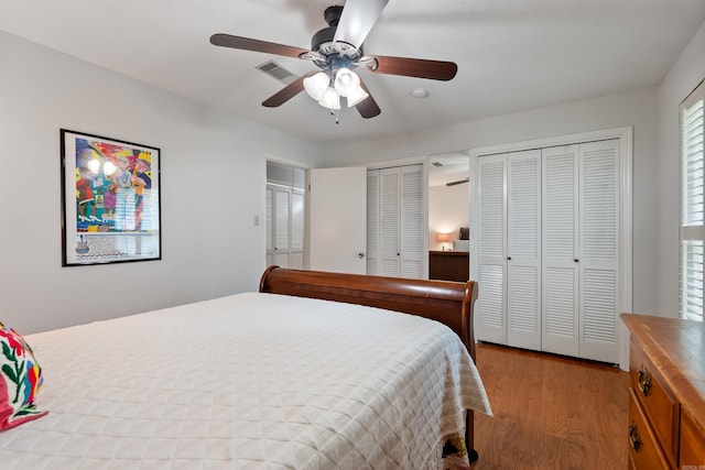 2608 Grist Mill Rd, Little Rock, AR 72227 - bedroom with multiple closets, light wood-style floors, and a ceiling fan