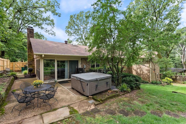 2608 Grist Mill Rd, Little Rock, AR 72227 - rear view of property with a hot tub, a patio, a fenced backyard, a shingled roof, and a chimney