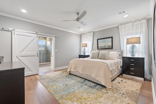 2690 Overcup Dr, Conway, AR 72034 - bedroom featuring crown molding, light wood finished floors, a ceiling fan, ensuite bathroom, and a barn door