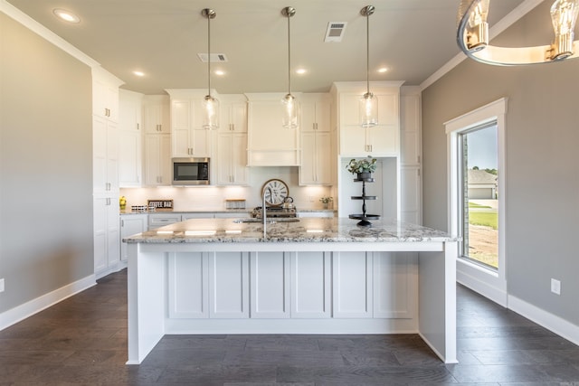 2690 Overcup Dr, Conway, AR 72034 - kitchen with stainless steel microwave, white cabinetry, a large island with sink, light stone countertops, and recessed lighting