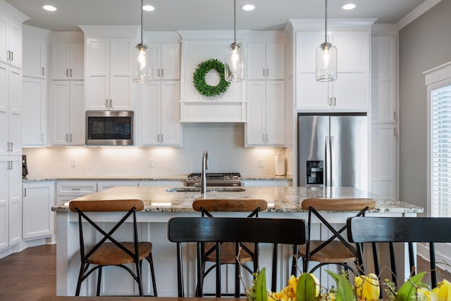 2690 Overcup Dr, Conway, AR 72034 - kitchen with appliances with stainless steel finishes, white cabinetry, recessed lighting, tasteful backsplash, and an island with sink