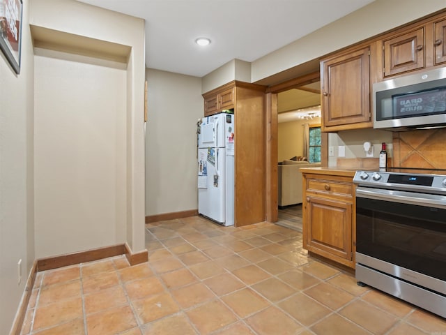 16 Almenara, Hot Springs Village, AR 71909 - kitchen with stainless steel appliances, brown cabinetry, light countertops, light tile patterned floors, and recessed lighting