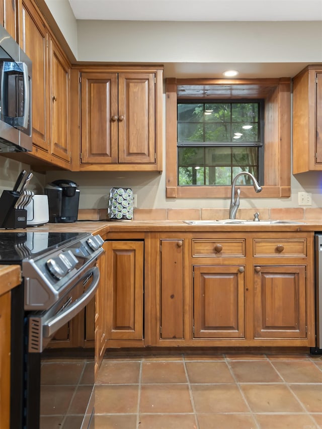16 Almenara, Hot Springs Village, AR 71909 - kitchen with stainless steel appliances, brown cabinets, light countertops, and tile patterned flooring