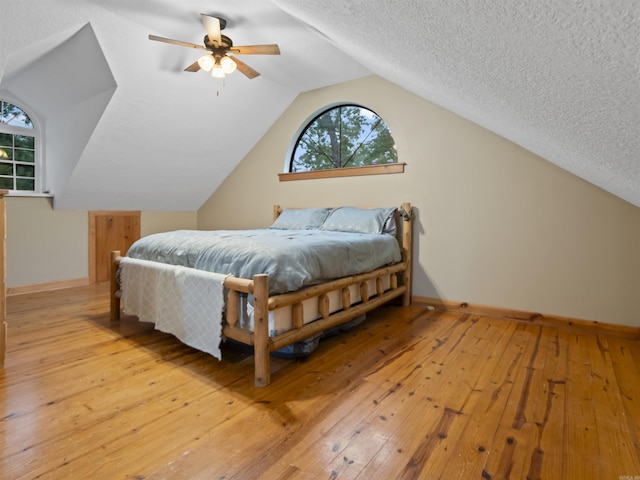 16 Almenara, Hot Springs Village, AR 71909 - bedroom featuring light wood-type flooring, lofted ceiling, a ceiling fan, and a textured ceiling