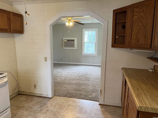 418 N Robinson St, Harrison, AR 72601 - kitchen featuring light carpet, ceiling fan, brown cabinets, a wall unit AC, and tile walls