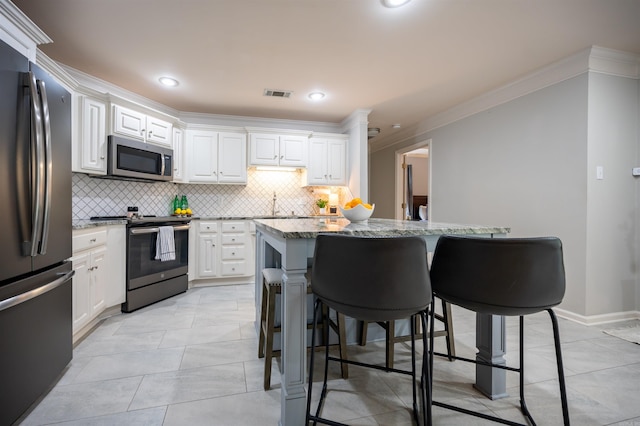 7139 Park Meadows Dr, Sherwood, AR 72120 - kitchen featuring appliances with stainless steel finishes, crown molding, light stone countertops, tasteful backsplash, and a breakfast bar area