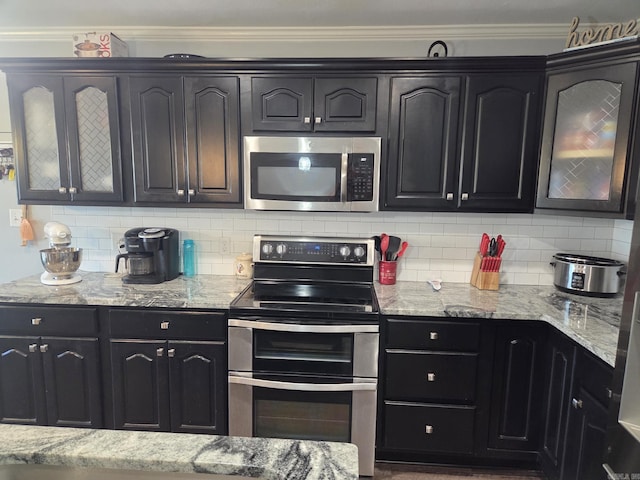 1209 Rehoboth, Searcy, AR 72143 - kitchen with appliances with stainless steel finishes, backsplash, light stone counters, glass insert cabinets, and ornamental molding