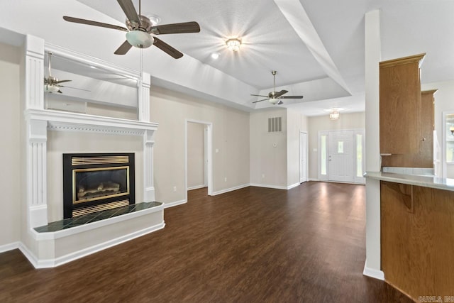 1226 Grayson Cir, Malvern, AR 72104 - unfurnished living room with ceiling fan, dark wood-style flooring, a glass covered fireplace, and a tray ceiling