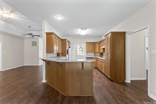 1226 Grayson Cir, Malvern, AR 72104 - kitchen featuring a peninsula, dark wood finished floors, a breakfast bar area, and ceiling fan