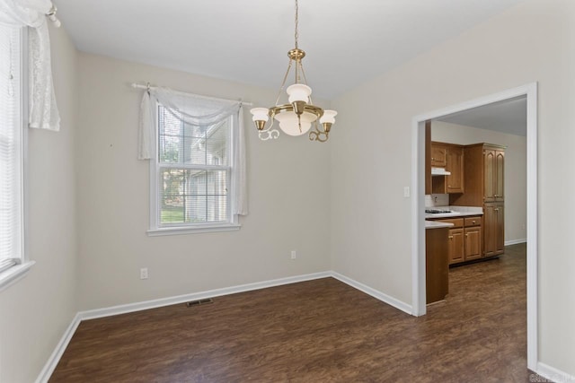 1226 Grayson Cir, Malvern, AR 72104 - spare room featuring a chandelier, dark wood-style flooring, and healthy amount of natural light