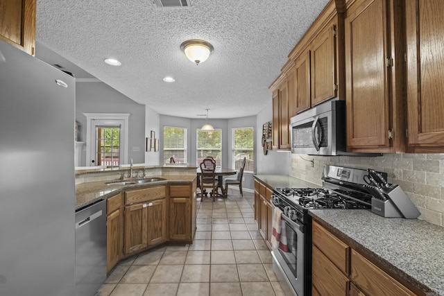 5132 Austin Lakes Cir, Sherwood, AR 72120 - kitchen with appliances with stainless steel finishes, brown cabinetry, healthy amount of natural light, a textured ceiling, and recessed lighting