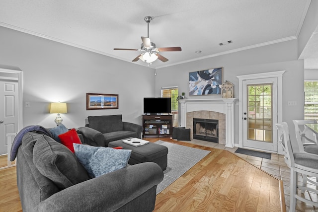 5132 Austin Lakes Cir, Sherwood, AR 72120 - living area with a tiled fireplace, ceiling fan, ornamental molding, and wood finished floors
