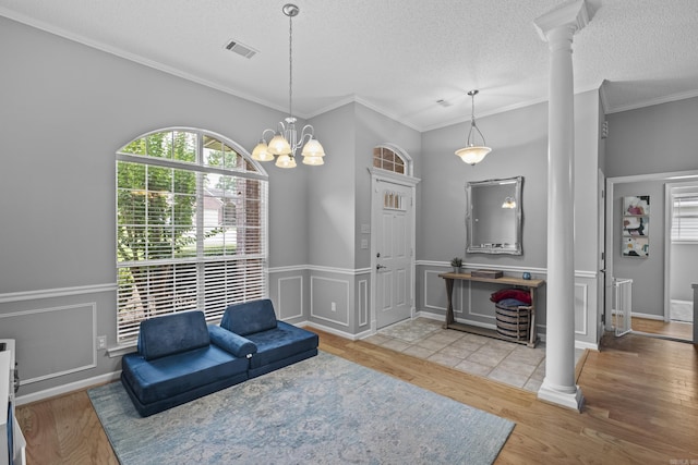 5132 Austin Lakes Cir, Sherwood, AR 72120 - living area featuring ornate columns, wood finished floors, crown molding, a textured ceiling, and wainscoting