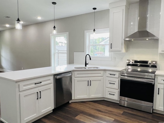 112 S Eagle, Sheridan, AR 72150 - kitchen featuring wall chimney range hood, appliances with stainless steel finishes, a peninsula, light countertops, and dark wood-type flooring