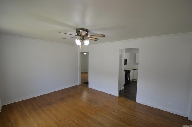 empty room featuring ceiling fan, dark wood-style floors, and ornamental molding
