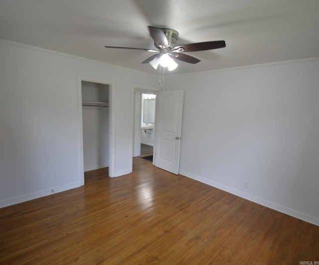 unfurnished bedroom with a closet, ornamental molding, wood finished floors, and ceiling fan