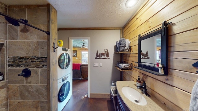 25 Jared Cir, Heber Springs, AR 72543 - full bathroom featuring stacked washer and clothes dryer, wooden walls, a tile shower, vanity, and a textured ceiling