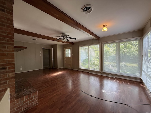 1073 Westwood Rd, Camden, AR 71701 - unfurnished living room with wood finished floors, beam ceiling, a ceiling fan, and a decorative wall