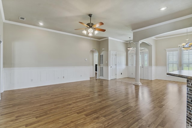 1726 Fox Run Dr, Wynne, AR 72396 - unfurnished living room featuring arched walkways, ornate columns, wood finished floors, a ceiling fan, and wainscoting