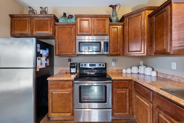 2355 Wilmington, Conway, AR 72034 - kitchen featuring appliances with stainless steel finishes, light countertops, and brown cabinetry