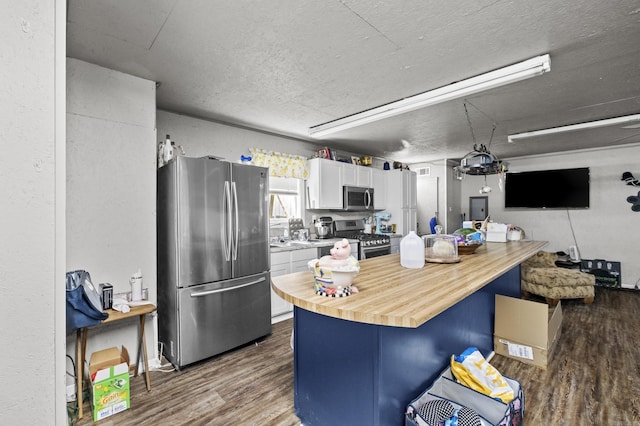 309 N Seaman St, Mccrory, AR 72101 - kitchen with stainless steel appliances, wood counters, dark wood finished floors, a textured ceiling, and white cabinetry