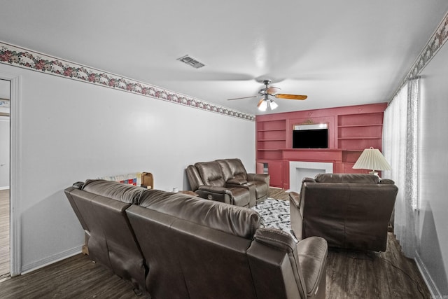 309 N Seaman St, Mccrory, AR 72101 - living area featuring a ceiling fan, wood finished floors, built in shelves, and a fireplace