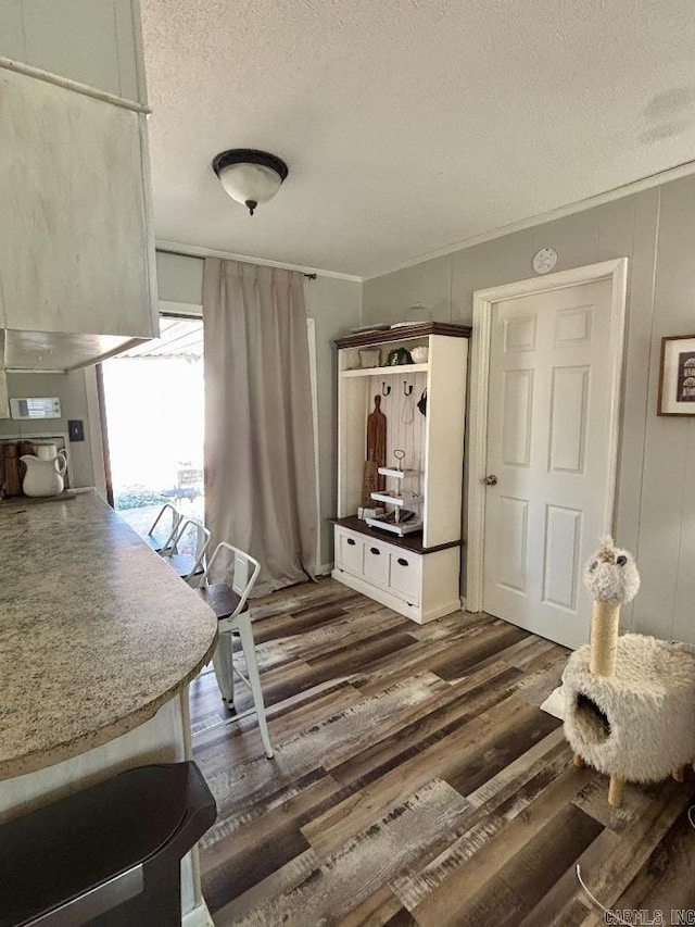 4 Paul St, Mcgehee, AR 71654 - dining room with a textured ceiling, dark wood-style flooring, and crown molding