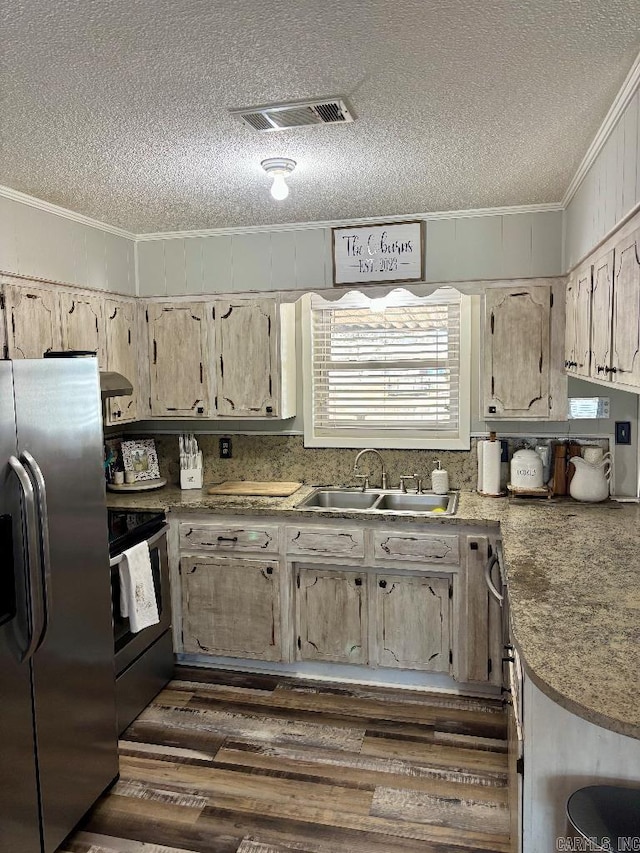 4 Paul St, Mcgehee, AR 71654 - kitchen with appliances with stainless steel finishes, crown molding, a textured ceiling, and dark wood-style floors