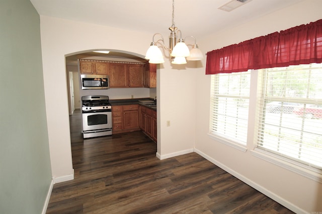 206 E Gum St, Sheridan, AR 72150 - kitchen featuring stainless steel appliances, a chandelier, arched walkways, dark wood-style flooring, and dark countertops