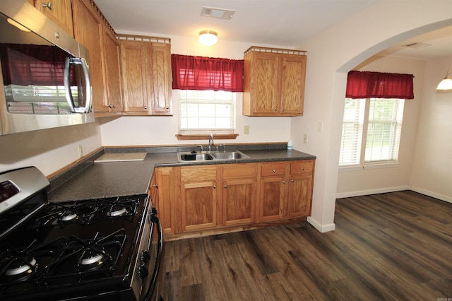 206 E Gum St, Sheridan, AR 72150 - kitchen with stainless steel appliances, dark countertops, dark wood-style floors, and healthy amount of natural light